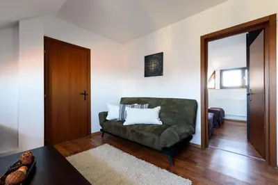 a living room with a green couch and a door at TWO BEDROOM Apartment in Bansko