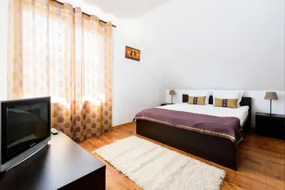 a bedroom with a bed and a flat screen tv at TWO BEDROOM Apartment in Bansko