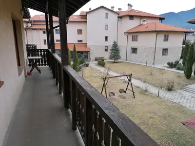 a balcony with a view of a yard with a swing at Top Lodge twobedroom apartment in Bansko