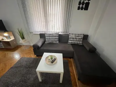 a living room with a couch and a table at Студио Рози апартамент in Sandanski