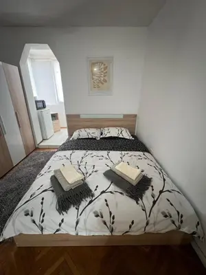 a bedroom with a bed with two pillows on it at Студио Рози апартамент in Sandanski