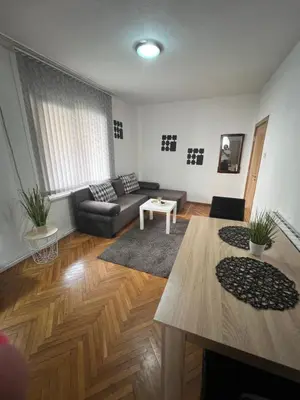 a living room with a couch and a table at Студио Рози апартамент in Sandanski