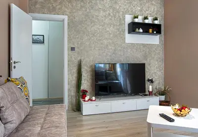 a living room with a television on a white cabinet at Ancient Serdica 2BDR Family Friendly City Retreat in Sofia