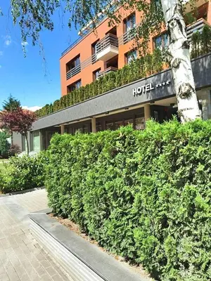a hedge in front of a hotel with a building at Aqua Viva Spa Hotel in Velingrad