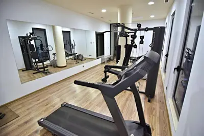 a gym with several tread machines and a mirror at Aqua Viva Spa Hotel in Velingrad