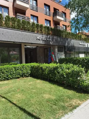 a hotel building with a lawn in front of it at Aqua Viva Spa Hotel in Velingrad
