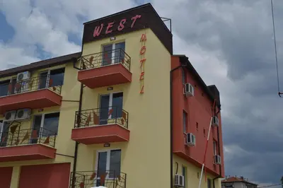 a yellow and red building with a sign on it at Hotel West in Blagoevgrad