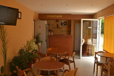 a restaurant with tables and chairs and a kitchen at Hotel West in Blagoevgrad