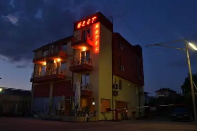 a hotel with a neon sign on the side of it at Hotel West in Blagoevgrad