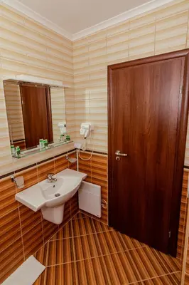 a bathroom with a sink and a wooden door at Lake View Apartment in Pamporovo