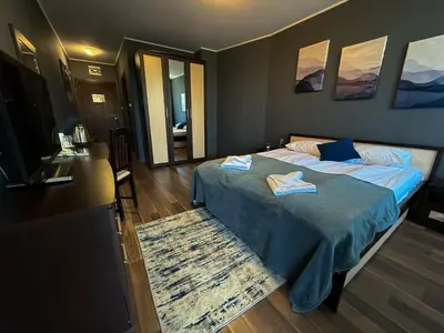a bedroom with a bed with blue sheets and a television at Hotel Iceberg Borovets in Borovets
