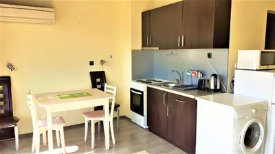 a small kitchen with a table and a sink at Sunny Days - Park Apartment in Sandanski