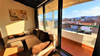 a living room with a couch and a large window at Sunny Days - Park Apartment in Sandanski