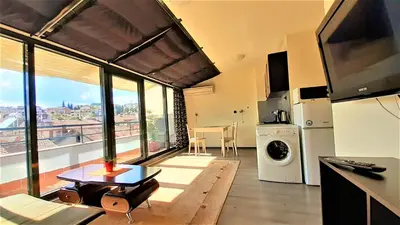 a kitchen with a living room with a large window at Sunny Days - Park Apartment in Sandanski