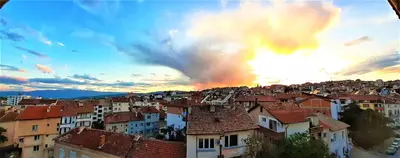 a view of a city at sunset with buildings at Sunny Days - Park Apartment in Sandanski