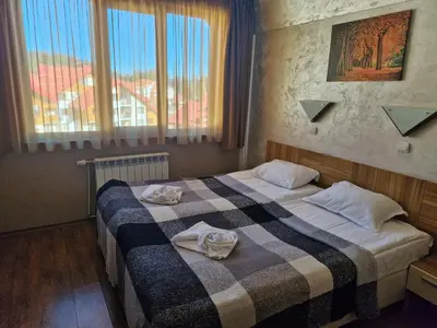 a hotel room with a bed with towels on it at Aparthotel Forest Nook in Pamporovo
