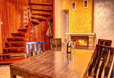 a wooden table in a room with a fireplace at Вили Forest Nook in Pamporovo