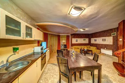 a kitchen and living room with a table and chairs at Вили Forest Nook in Pamporovo
