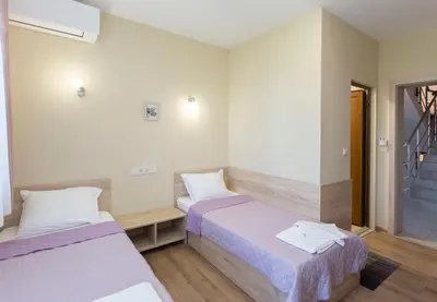 a small room with two beds and a window at Къща за гости Перуника in Sapareva Banya