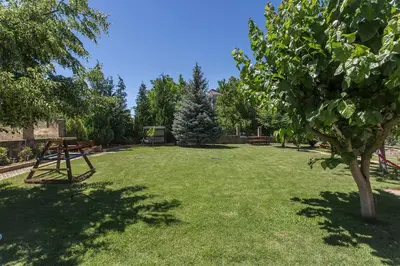 a large yard with a picnic table and trees at Къща за гости Перуника in Sapareva Banya