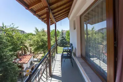 a balcony with a table and chairs on it at Къща за гости Перуника in Sapareva Banya