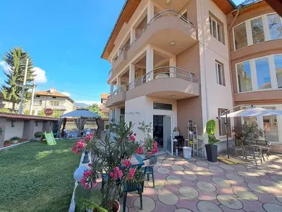 a house with a patio with chairs and flowers at Приятелската къща in Velingrad