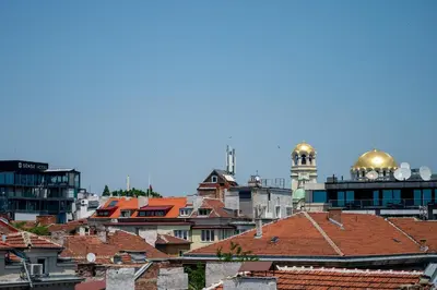 a view of a city with roofs and a clock tower at Sunny Studio with a view in TOP Center in Sofia