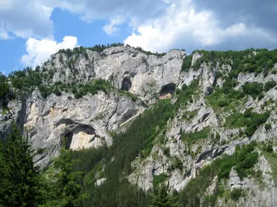 a rocky mountain with two tunnels in it at Къща край реката - Триград in Trigrad