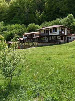 a large house in a field of green grass at Къща за гости 