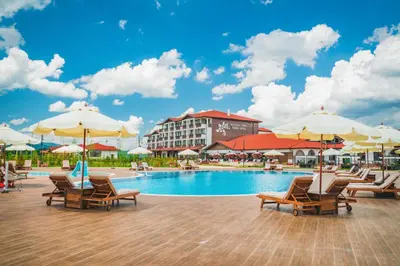 a swimming pool with chairs and umbrellas and a hotel at SPA Complex Belchin Spring in Belchin