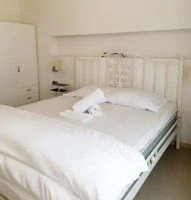 a white bed with a teddy bear sitting on it at Top Center Apartment next to Vitosha Boulevard in Sofia