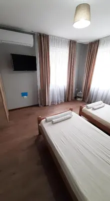 a hotel room with two beds and a flat screen tv at Къща за гости Чечев in Sapareva Banya