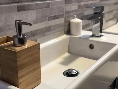 a bathroom sink with a faucet and a soap dispenser at Къща за гости Чечев in Sapareva Banya