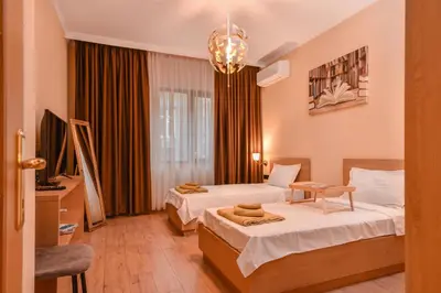 a hotel room with two beds and a chandelier at Sofia Dream Apartment - The Library - 3-BDR, 2-BTHR by Flat Mаnager in Sofia