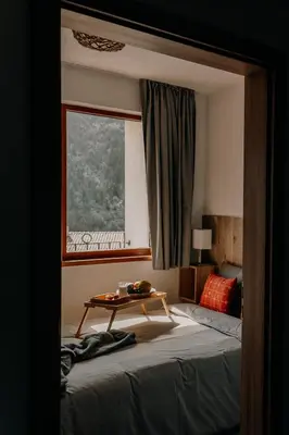 a bedroom with a bed with a table on it at Magnificent apartment in the mountains in Banite