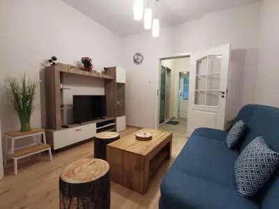 a living room with a blue couch and a tv at Rila Apartment in Sofia