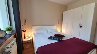 a bedroom with a white bed with a purple blanket at Borovets Holiday Homes in Borovets