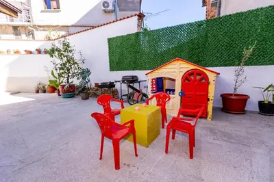 a group of red chairs and a play house at Къща за гости Калинови in Sandanski