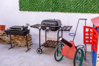 a grill and a bbq cart next to a table at Къща за гости Калинови in Sandanski
