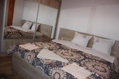 a bedroom with a large bed with a mirror at СТУДИО-ЛАМБО in Sandanski