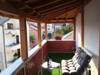 a balcony with couches and a table on a building at СТУДИО-ЛАМБО in Sandanski