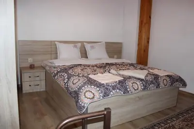 a bedroom with a large bed with a wooden headboard at СТУДИО-ЛАМБО in Sandanski