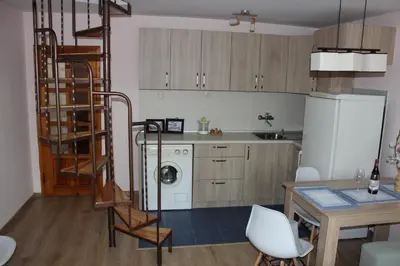 a kitchen with a spiral staircase in a kitchen at СТУДИО-ЛАМБО in Sandanski
