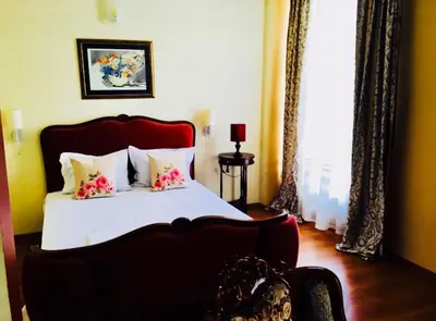 a bedroom with a large bed with flowers on it at Hotel Shterev Karlovo in Karlovo