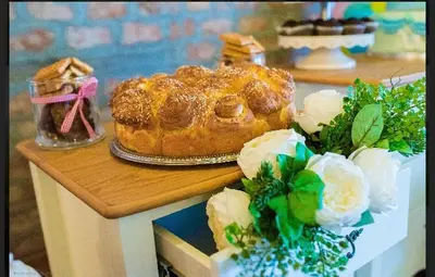a table with a cake on a table with flowers at Hotel Shterev Sopot in Sopot