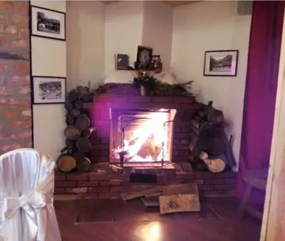 a brick fireplace with a fire in a room at Hotel Shterev Sopot in Sopot