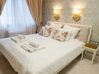 a bedroom with a white bed with towels on it at Paradise Center Premium Suite 1 in Sofia