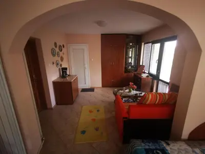 a living room with a red couch and a yellow rug at Къщата на Румен in Sofia