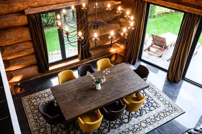 a dining room with a wooden table and yellow chairs at Alpina Luxury Chalets in Banya