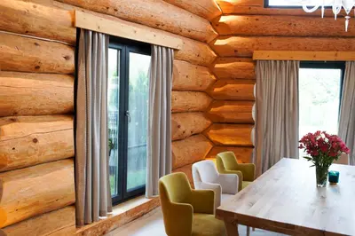 a dining room with a wooden wall at Alpina Luxury Chalets in Banya